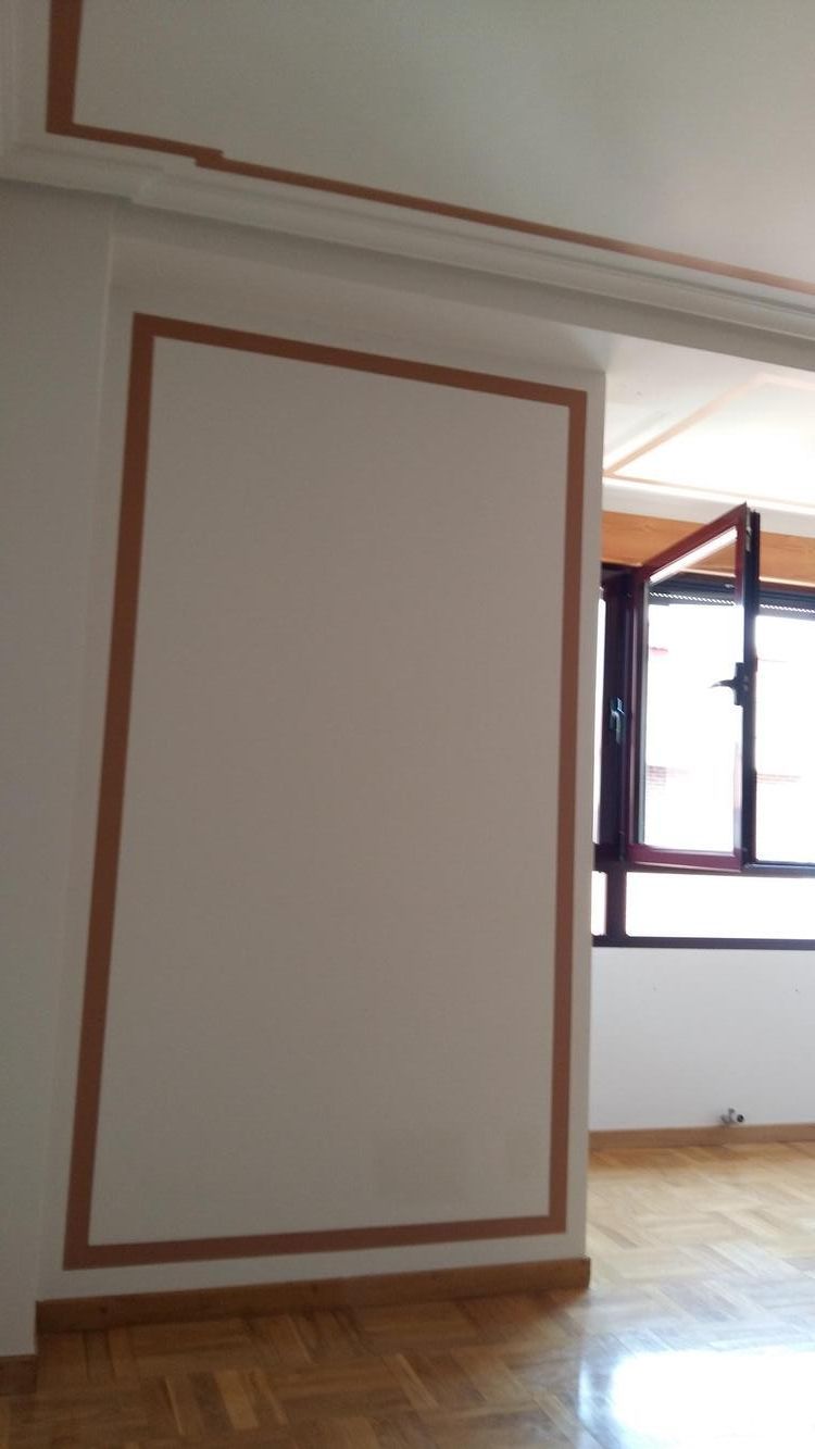 Una habitación vacía con una ventana y una pared blanca.