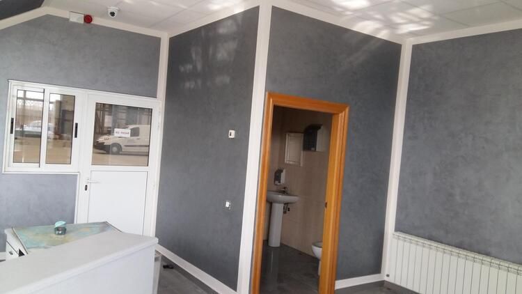 Una habitación con un lavabo y una puerta que conduce a un baño.