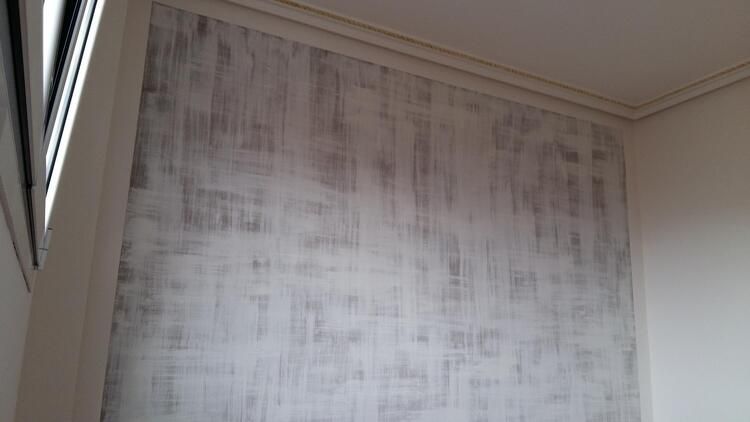 Un rincón de una habitación con una pared blanca y una ventana.