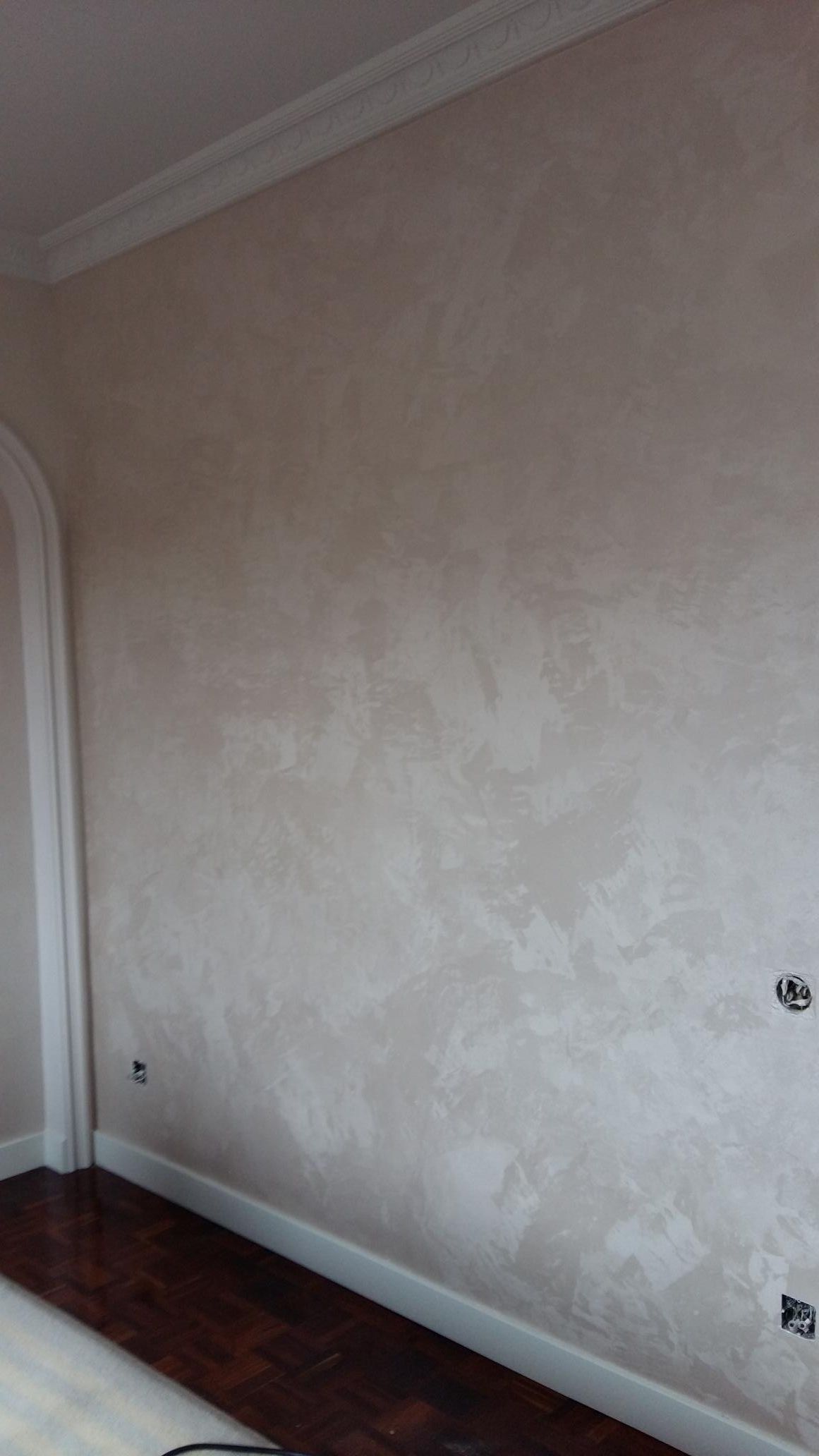 Una habitación con una pared blanca y un suelo de madera.