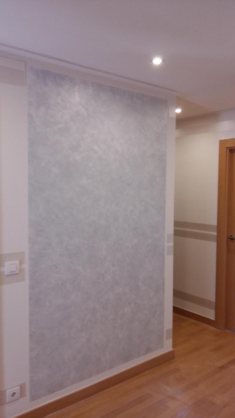 Una sala de estar con una pared blanca y un suelo de madera.