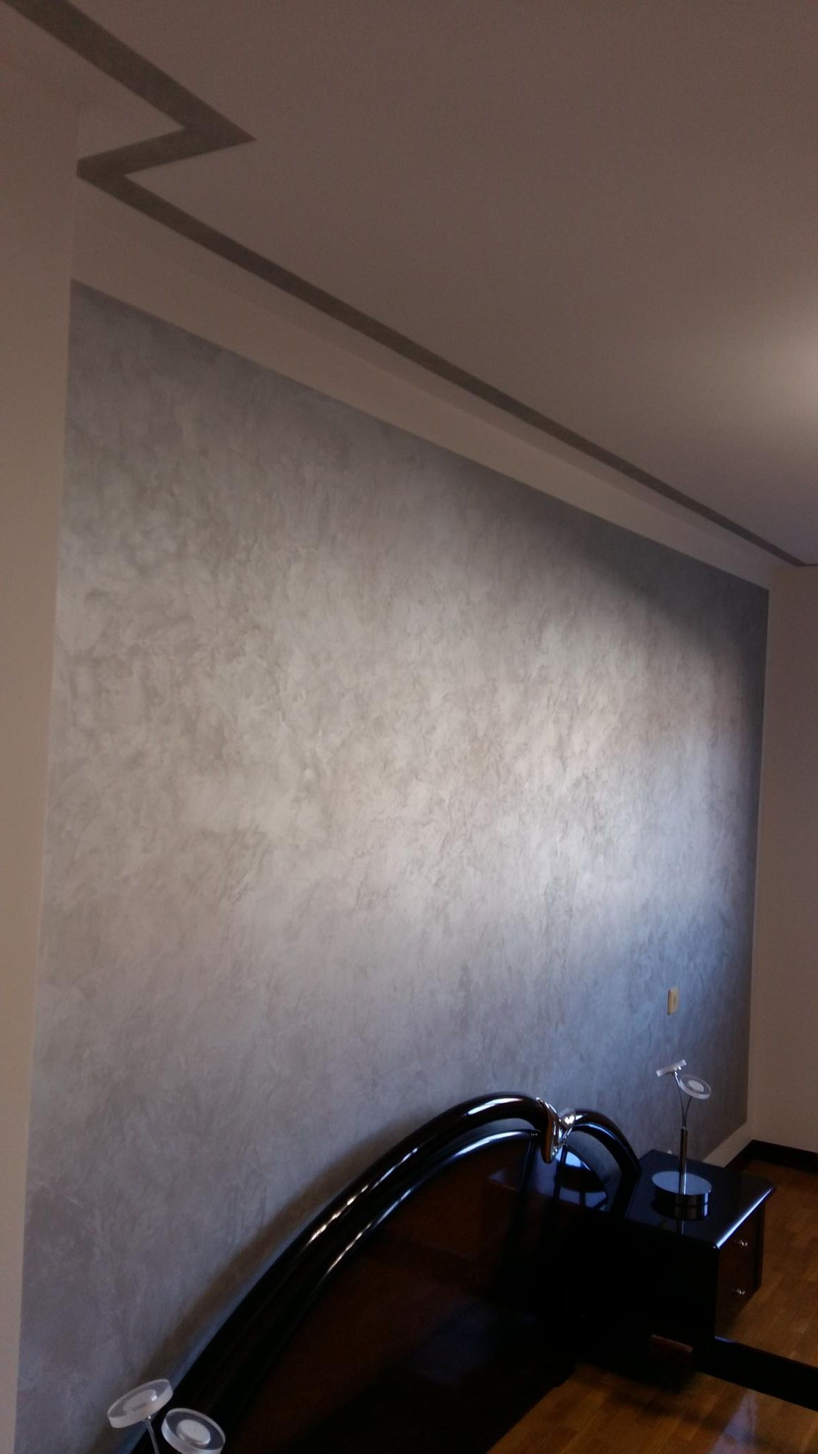 Una habitación con una pared gris y una silla negra