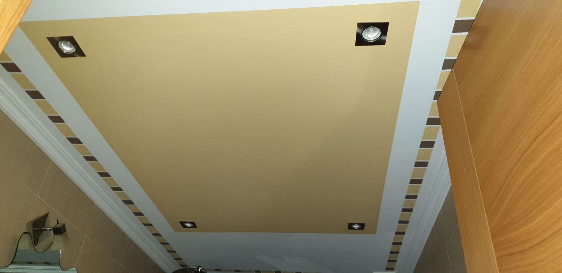 Un pasillo con un techo que tiene luces cuadradas.