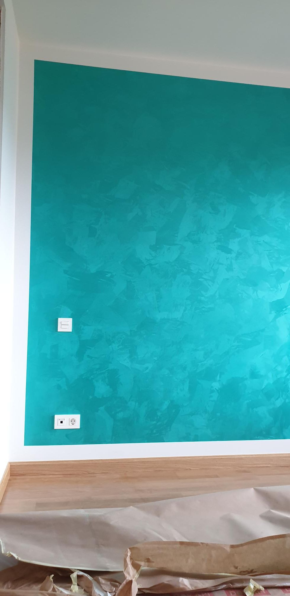 Una habitación con una pared azul y un suelo de madera.