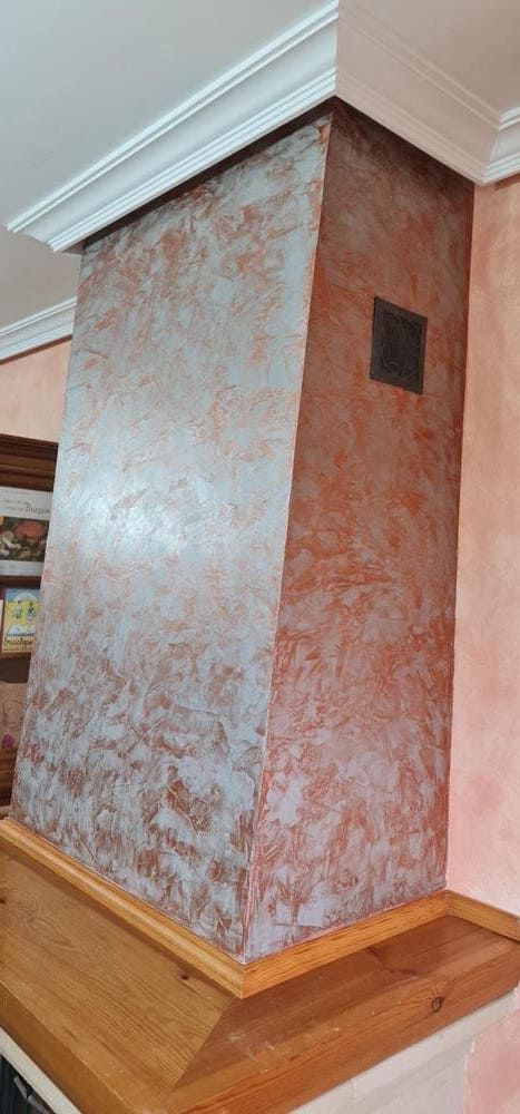 Una chimenea con un estante de madera debajo en una cocina.