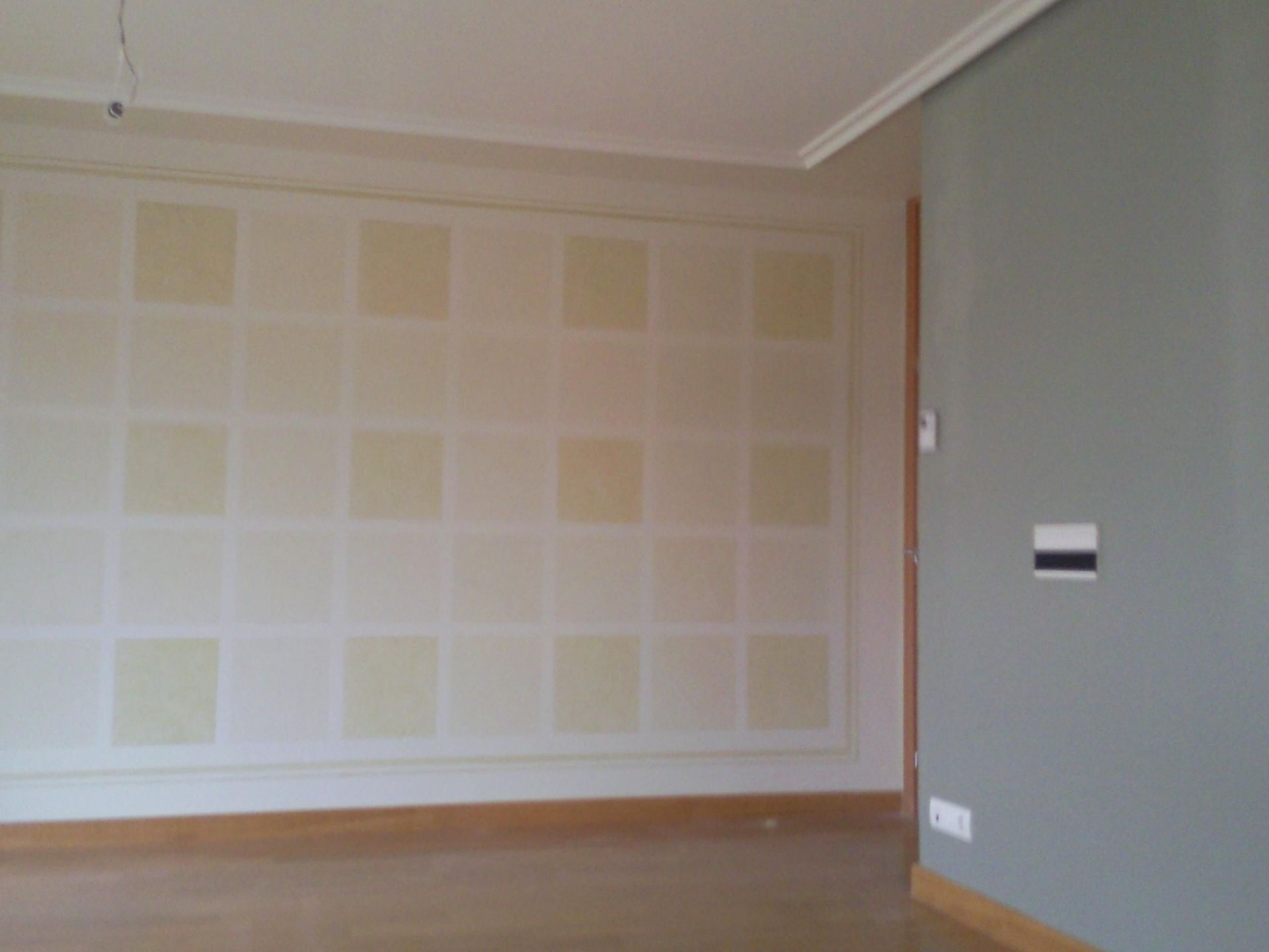 Una habitación vacía con cuadrados en la pared y una puerta.