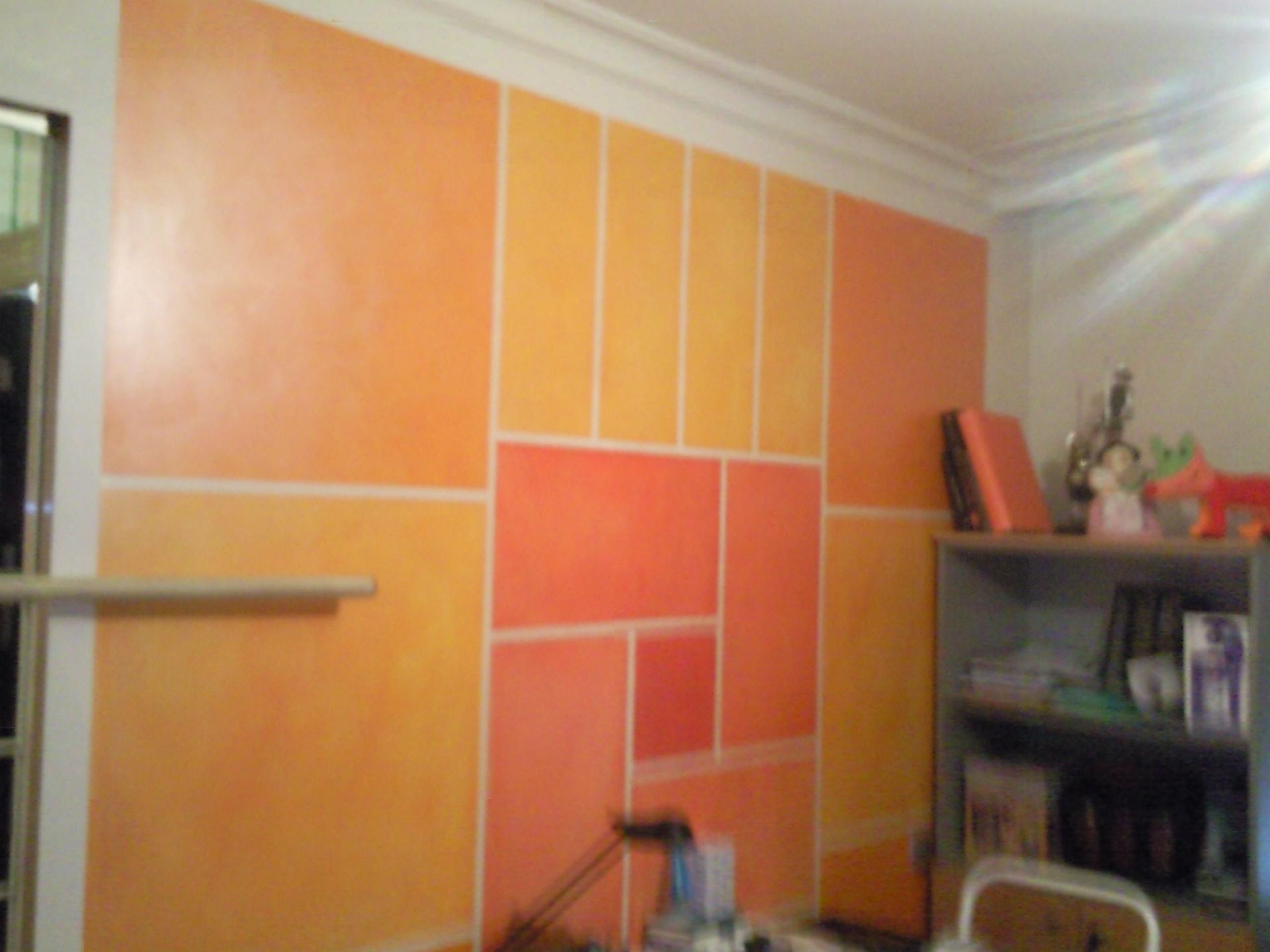Una habitación con una pared pintada de color naranja y amarillo.