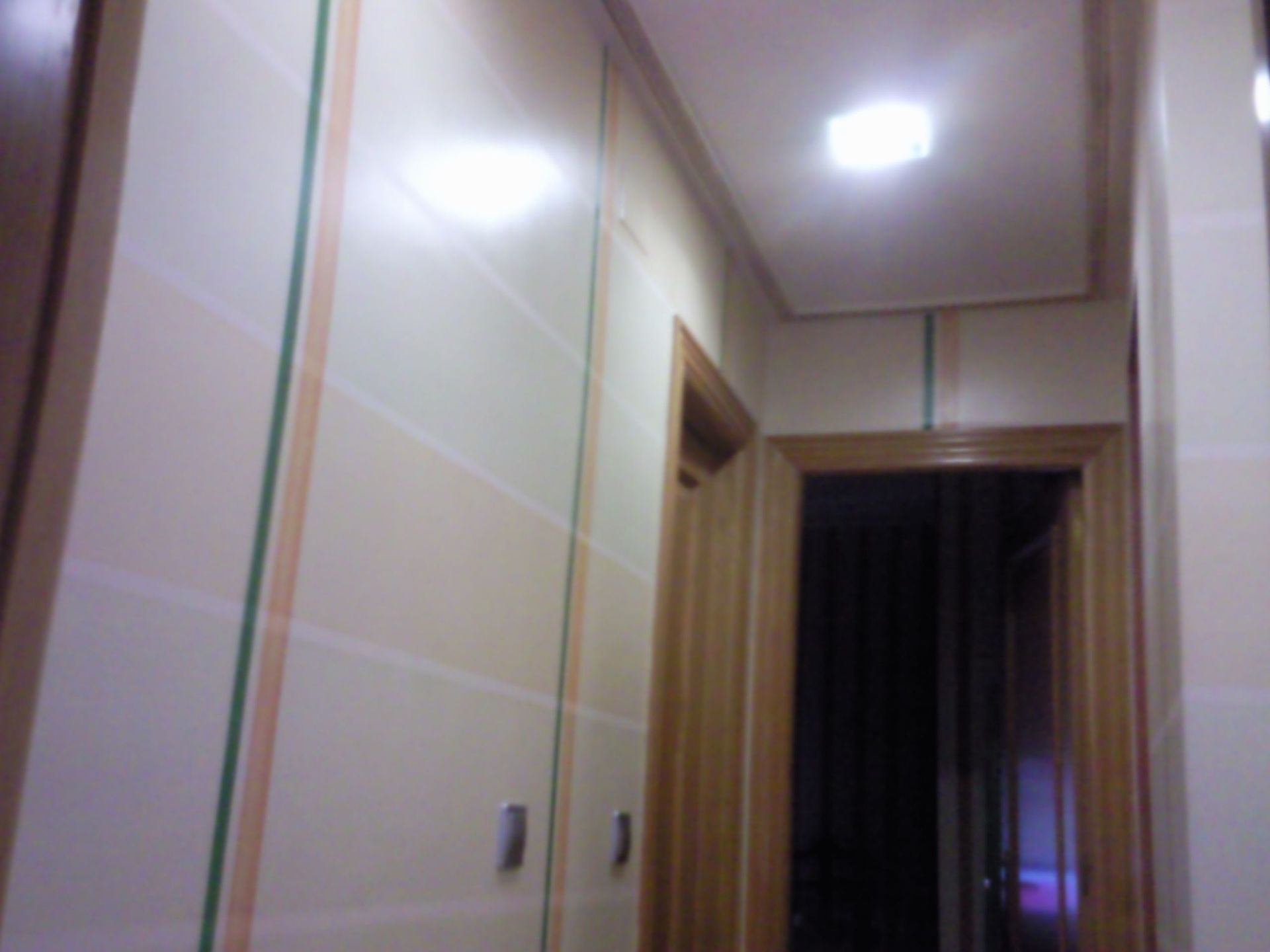 Un pasillo con una puerta y una luz en el techo.