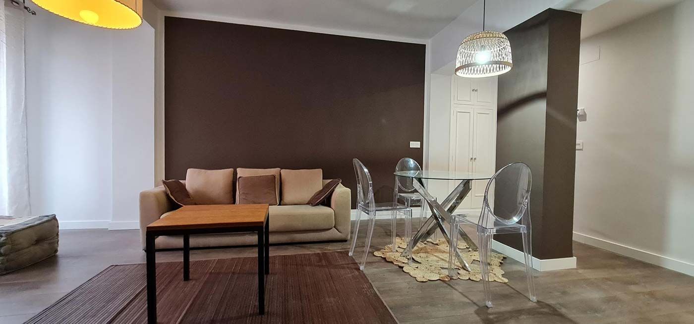 Una sala de estar con sofá, mesa y sillas.