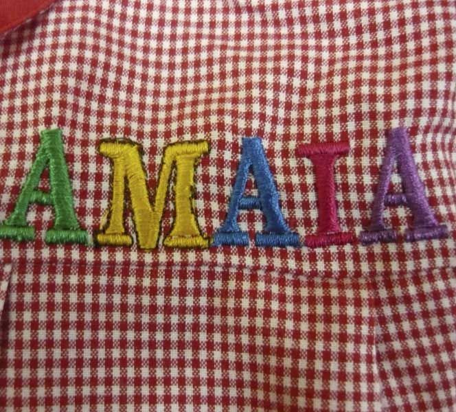 Una camisa a cuadros roja y blanca con el nombre amaya bordado en ella