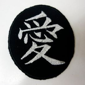 Un parche negro con un símbolo chino blanco sobre él.