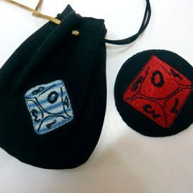 Una bolsa negra con un dado bordado en ella.