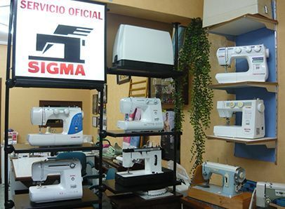 Varias máquinas de coser están en exhibición bajo un cartel que dice servicio oficial