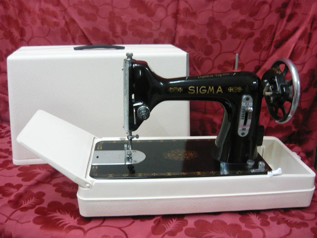 Una máquina de coser Sigma se encuentra en un estuche blanco.