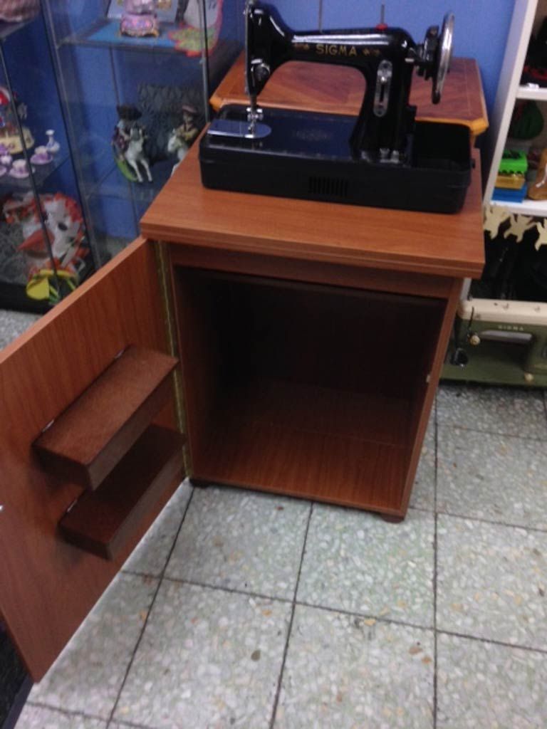 Una máquina de coser está colocada encima de una mesa de madera.