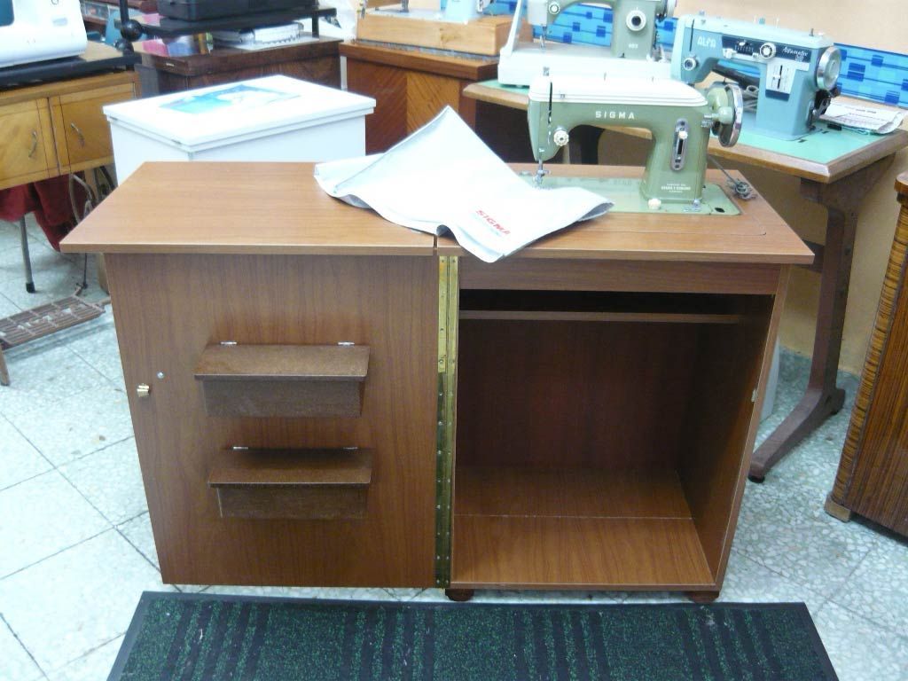 Una máquina de coser está sobre una mesa de madera.