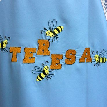 Una camisa azul con el nombre Teresa bordado en ella.