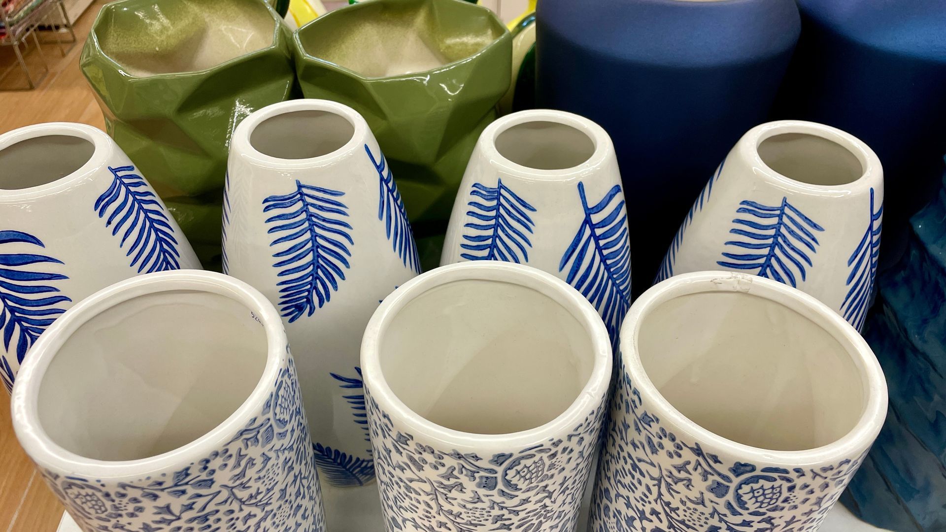 Vases en céramique blanche assortis, ornés de motifs bleus, disposés sur une table