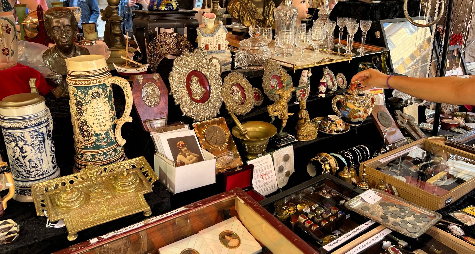 Horloges, vases et bibelots dorés de toutes sortes sont exposés sur un étal de marché d'antiquités.