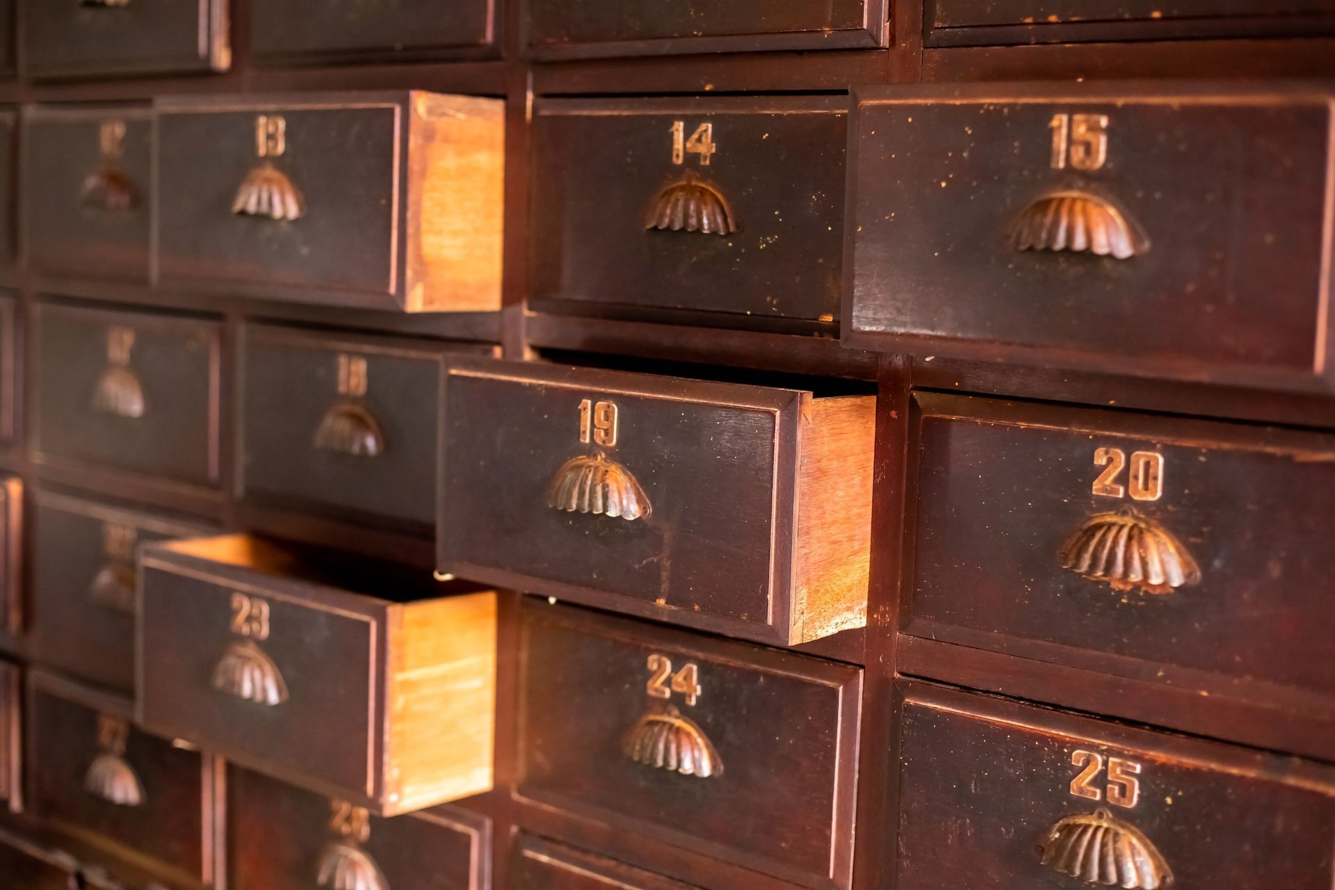 Anciens tiroirs en bois avec numéros en laiton.