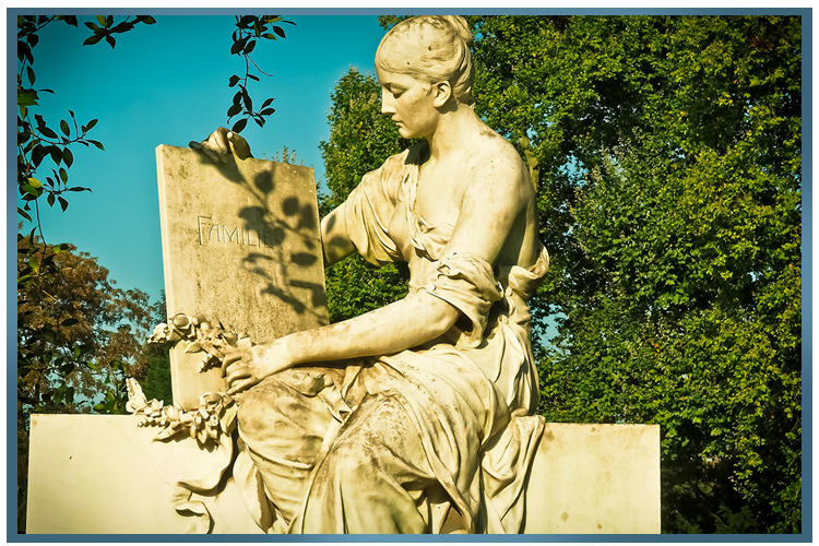 Statue dans un jardin d'une femme assise près d'une pierre, en extérieur, tenant des fleurs.