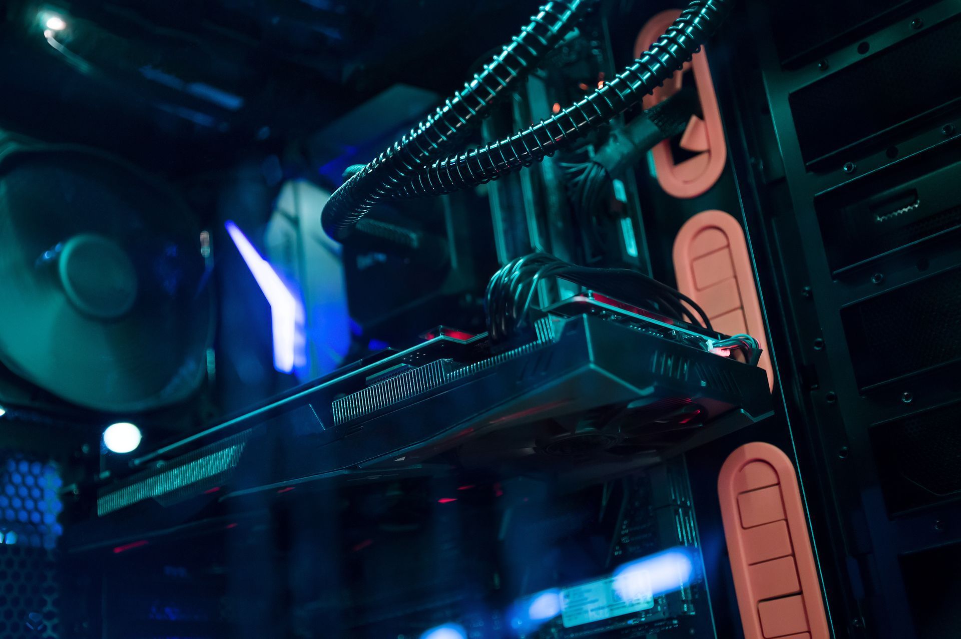 À l'intérieur d'un boîtier d'ordinateur, une carte graphique est montée avec un système de refroidissement liquide, illuminé en bleu.