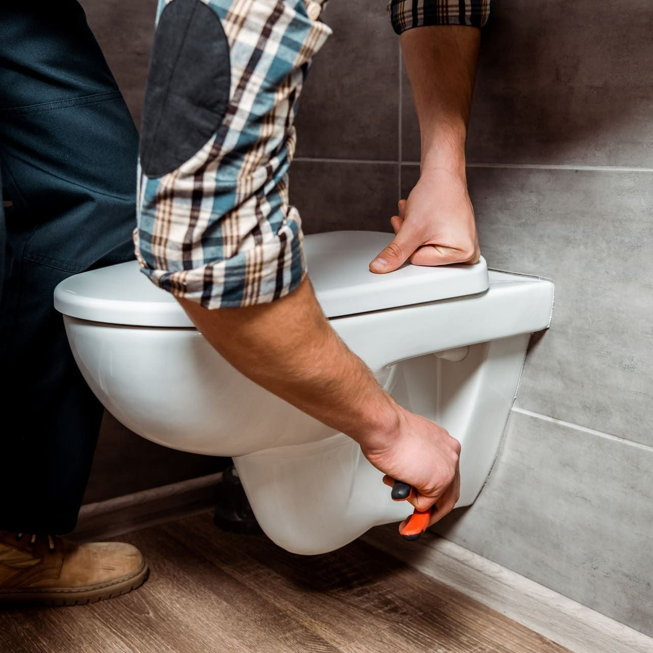 Un homme qui pose des toilettes