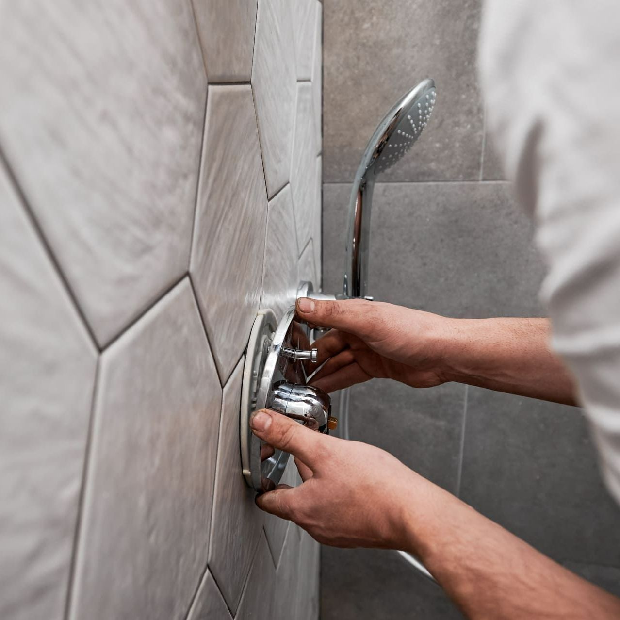 Un homme qui pose son robinet de douche