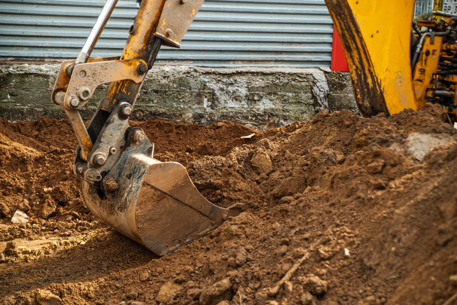 Une excavatrice creuse un sol sur un chantier de construction.