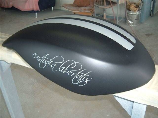 Schwarzer Motorradkotflügel mit silbernen Streifen und dem kursiven Schriftzug „custodia libertatis“.