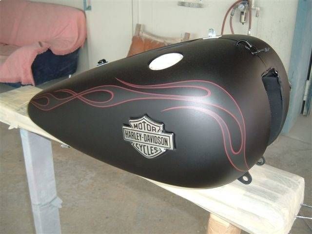 Schwarzer Motorrad-Benzintank mit roten Flammen und Harley-Davidson-Logo.