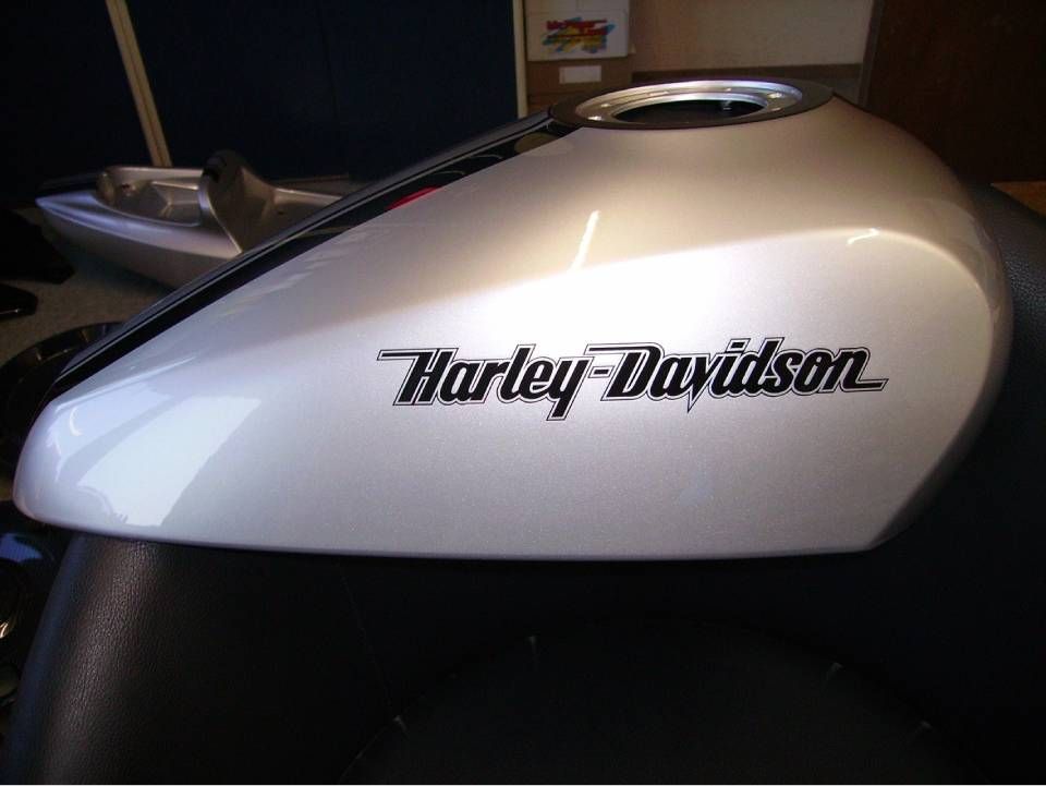Silberner Harley-Davidson-Motorradtank mit schwarzem Logo.