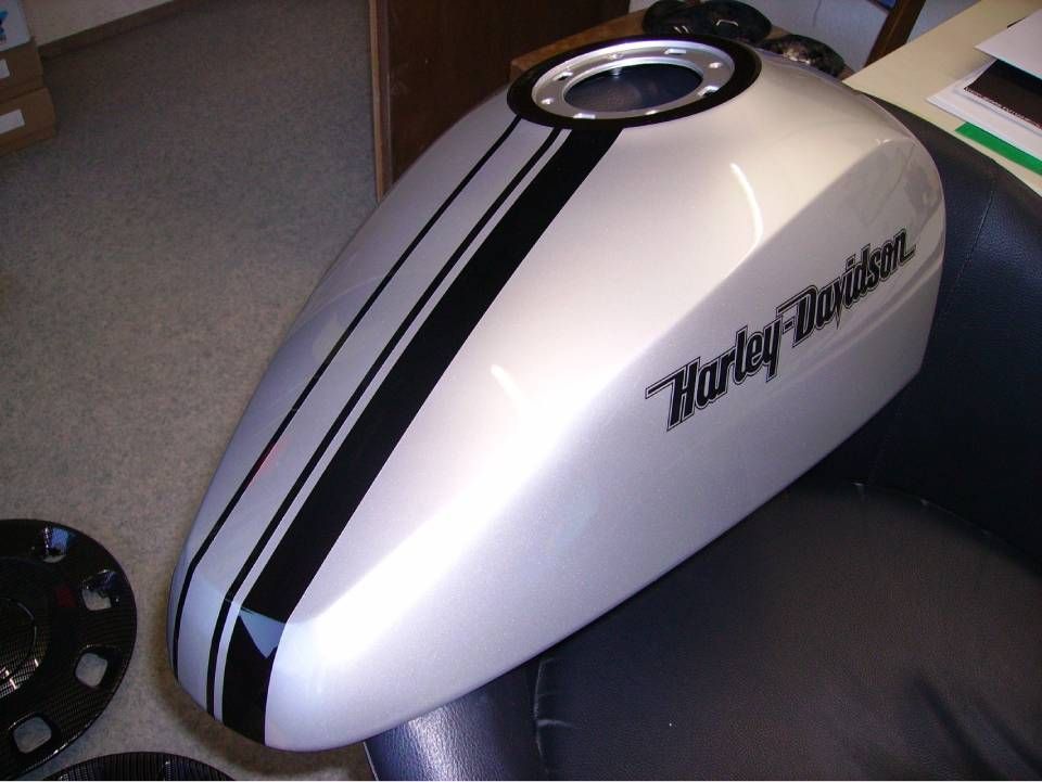 Silberner Harley-Davidson-Motorradtank mit schwarzen Rennstreifen und Logo.