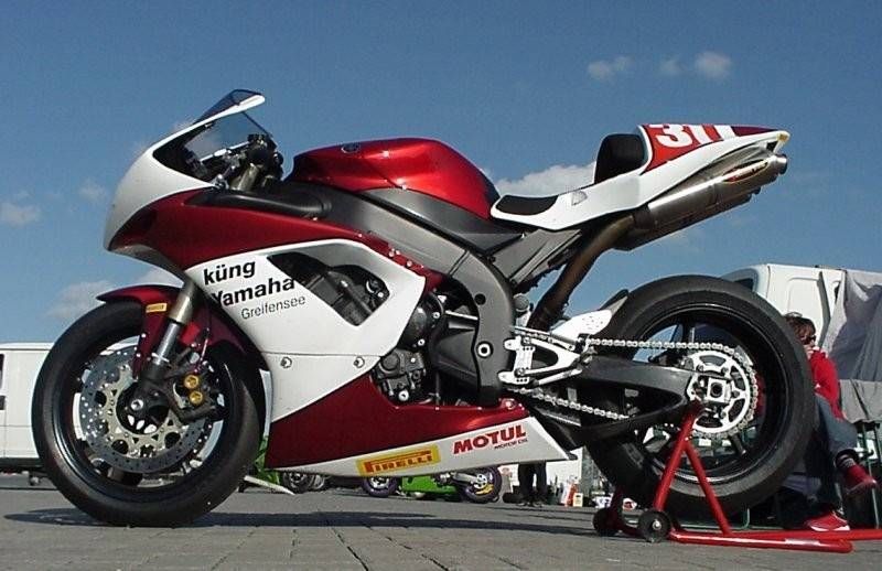 Rotes und weisses Yamaha-Rennmotorrad auf einem Ständer. „Küng Yamaha“-Etikett.