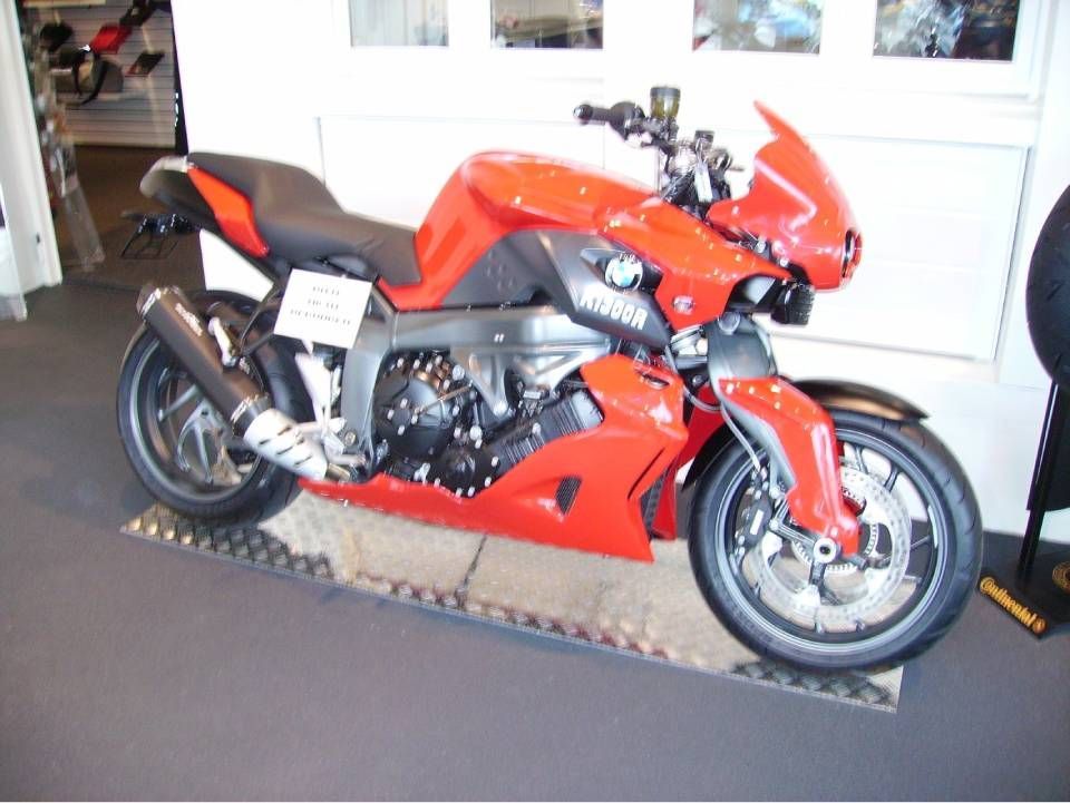 Rotes BMW K1300R Motorrad mit silbernen und schwarzen Akzenten im Ausstellungsraum.