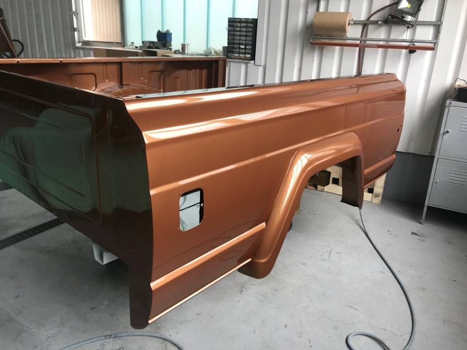 Die Ladefläche eines braunen Pick-ups wurde in einer Werkstatt frisch lackiert.