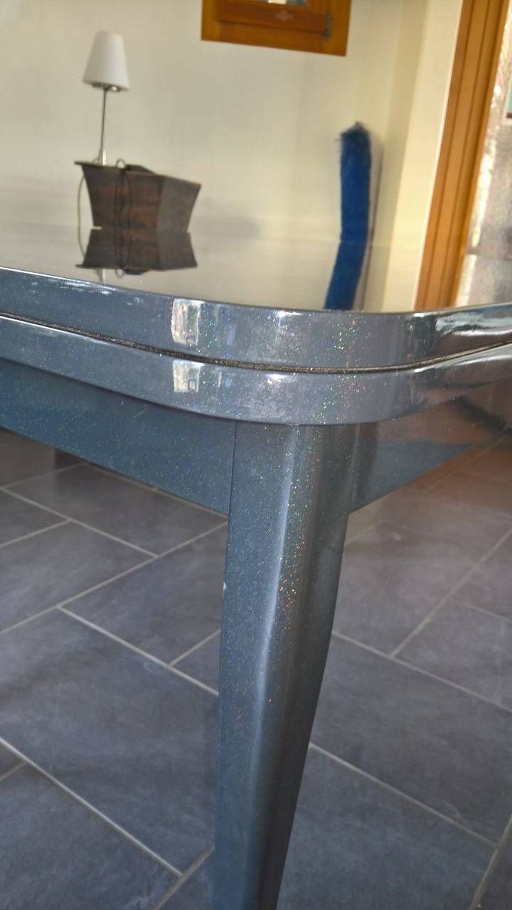 Grauer rechteckiger Tisch mit Glitzeroberfläche, Innenbereich. Fliesenboden.