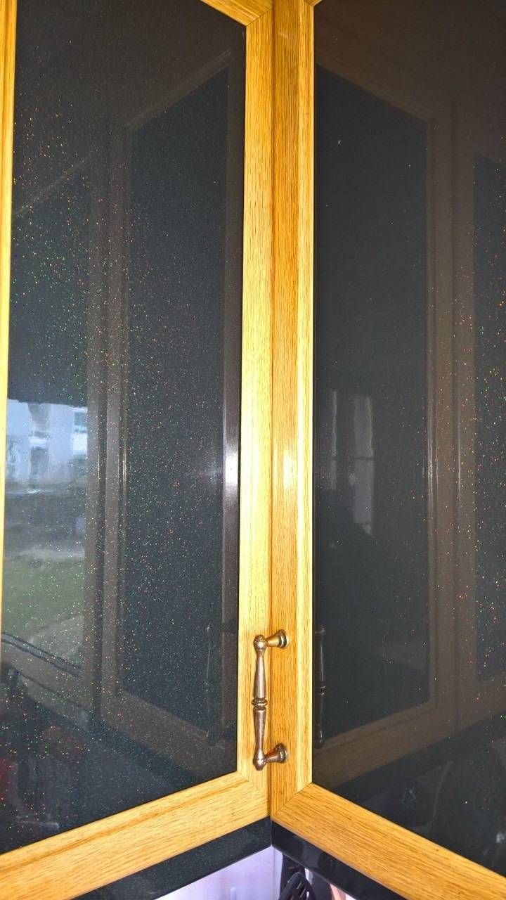 Küchenschranktüren aus Holz mit Glaseinsätzen und Messinggriff.