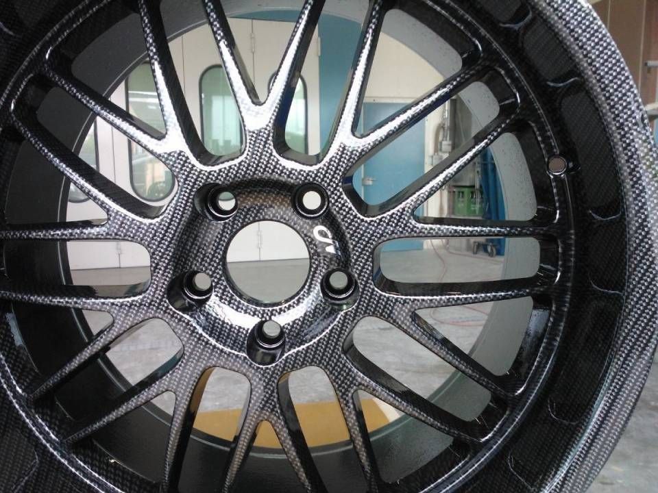 Autorad aus Kohlefaser, schwarz und silber, mit mehreren Speichen, im Innenbereich.