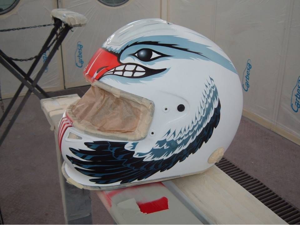 Weisser Motorradhelm mit Adlermotiv: roter Schnabel, blau-weisser Kopf, schwarze Flügeldetails.