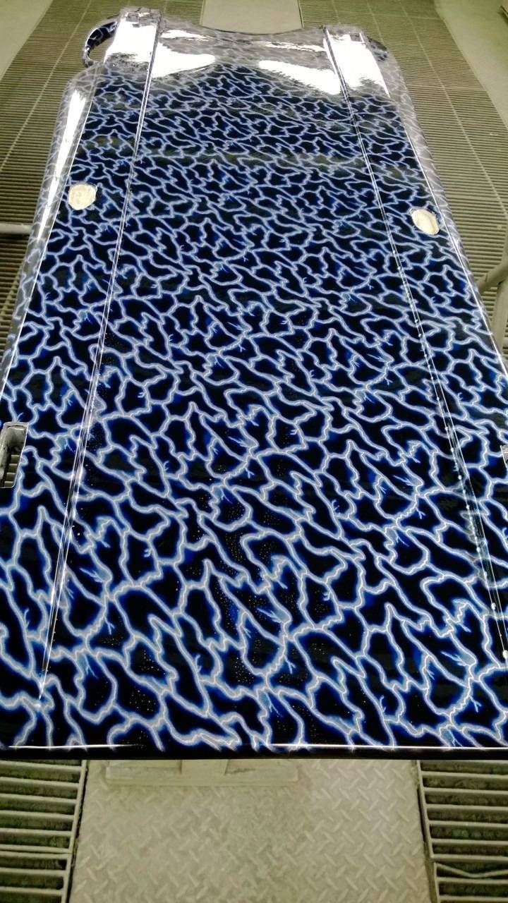 Dunkelblaue Oberfläche mit weissem, organisch geformtem Muster.