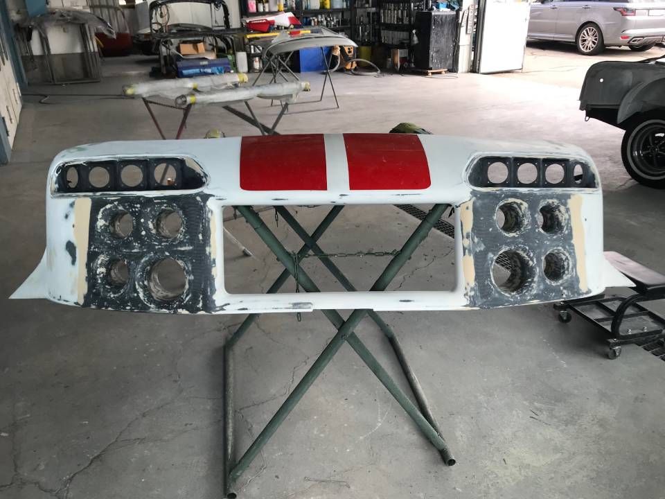 Ein weiss-rotes Armaturenbrett steht auf einem Ständer in einer Garage und ist für den Einsatz vorbereitet.