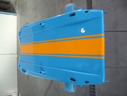 Blaue Autotür mit orangefarbenen und türkisfarbenen Rennstreifen in einer Lackierkabine.