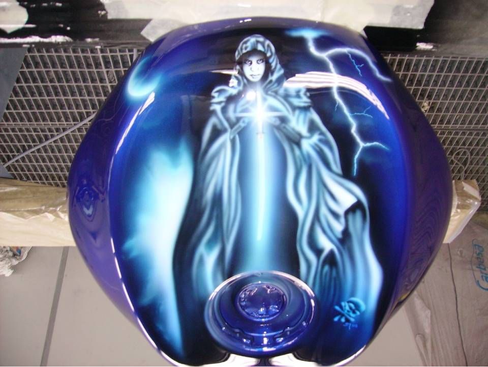 Blauer Motorradtank mit Airbrush-Abbildung einer vermummten Gestalt, die Licht ausstrahlt, mit Blitzen.