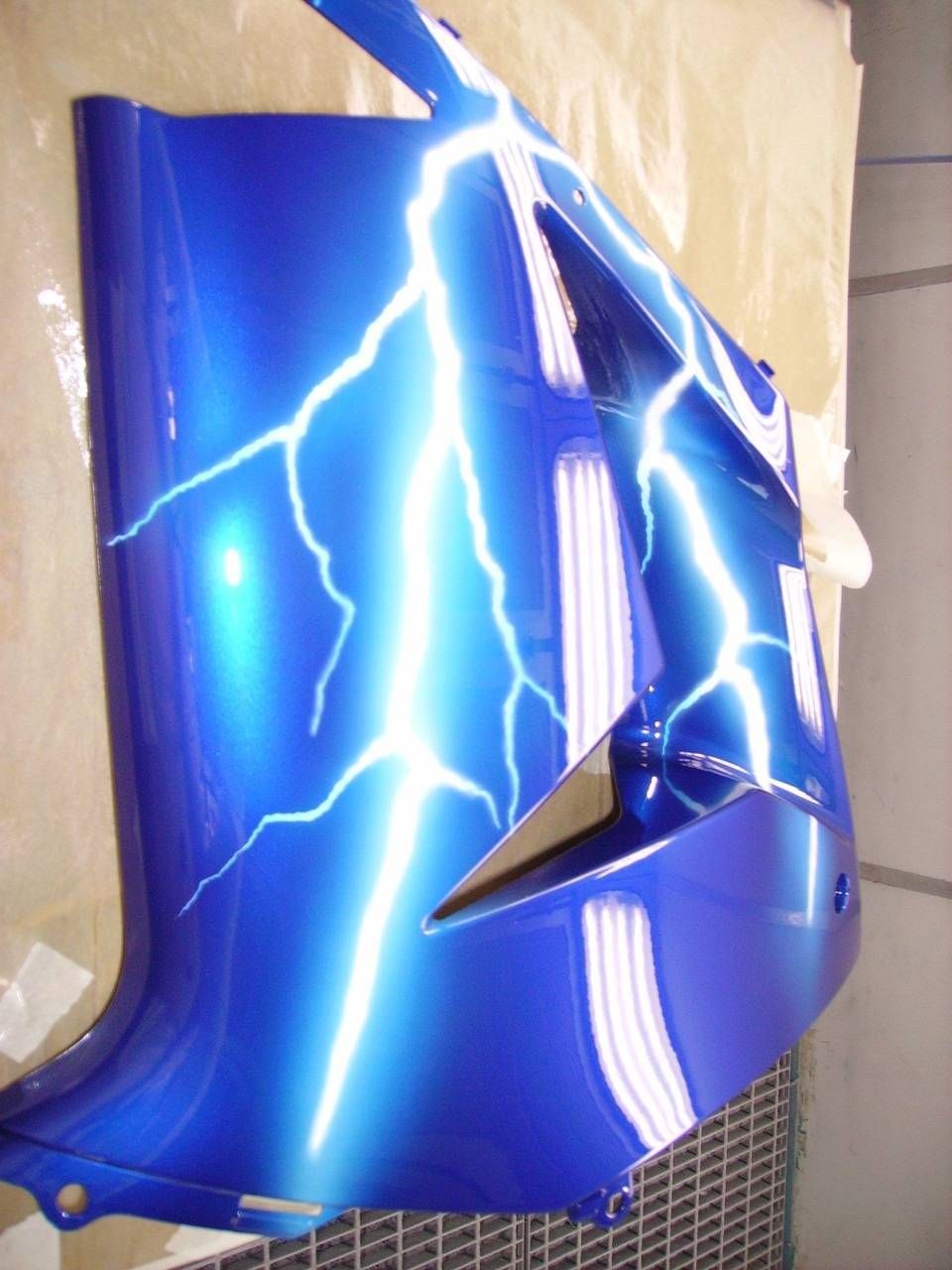 Blaue Motorradverkleidung mit weissem Blitzmotiv.