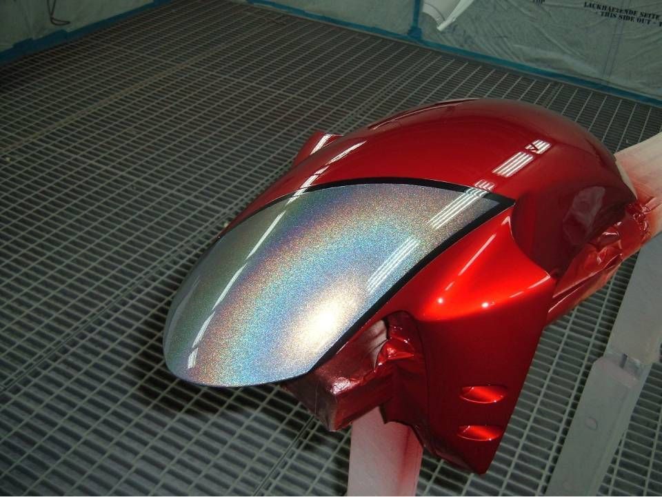 Rote Motorradverkleidung mit schillernden silbernen Akzenten.