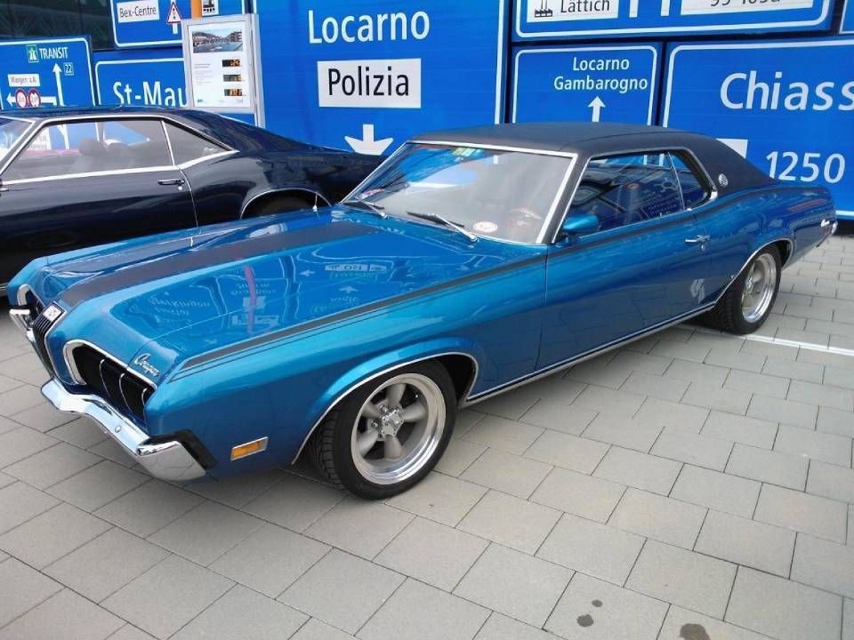 Blauer Oldtimer, Mercury Cougar, geparkt, mit schwarzem Rennstreifen und Chromdetails.