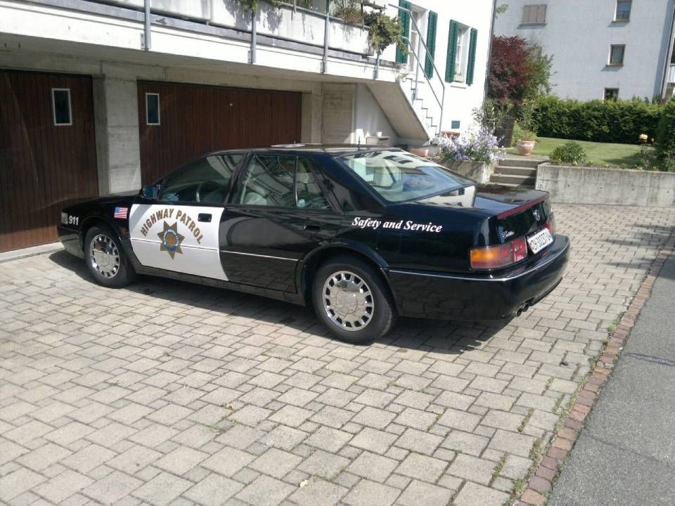 Ein schwarz-weisser Streifenwagen der California Highway Patrol parkt vor einem Haus auf einer gepflasterten Auffahrt.