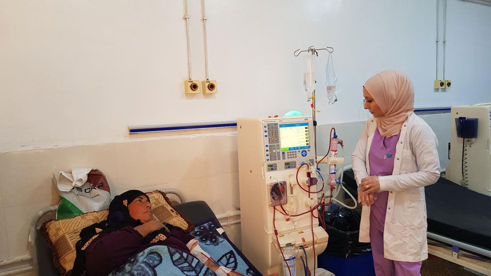 Eine Frau erhält im Krankenhaus eine Dialysebehandlung; eine Krankenschwester überwacht das Gerät.