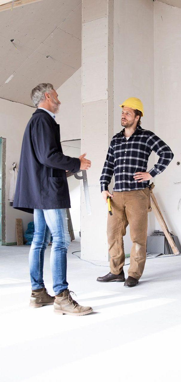 Un expert et un ouvrier discutant sur un chantier